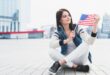 woman-sitting-square-holding-american-flag-hand_23-2148157182~2