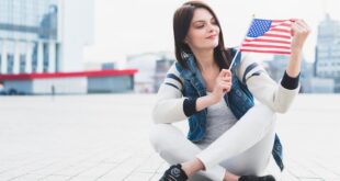 woman-sitting-square-holding-american-flag-hand_23-2148157182~2
