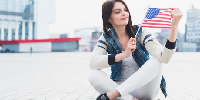 woman-sitting-square-holding-american-flag-hand_23-2148157182~2